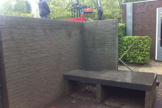 cementeren van een tuinmuur en het leggen van een betonplaat voor een leuk knus zitje